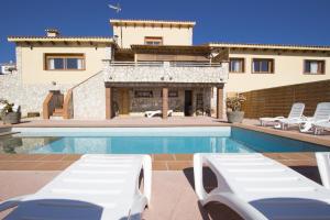 a villa with a swimming pool in front of a house at Catalunya Casas Indoor and Outdoor Pools, Sauna, Gym, Games Area in Sant Pau dʼOrdal