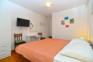 - une chambre avec un lit et une télévision murale dans l'établissement Apartment Brajdine 405, à Medulin