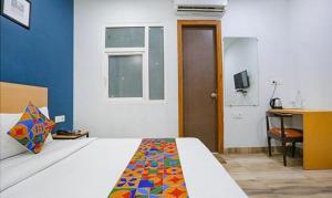 1 dormitorio con cama, escritorio y ventana en FabHotel F9 Prime Executive Paschim Vihar en Nueva Delhi
