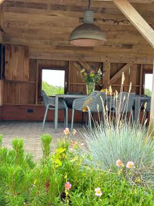 un patio con mesa, sillas y plantas en Scholtefleer en De Lutte