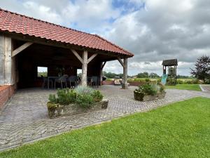 a pavilion with a table and chairs in a yard at Scholtefleer in De Lutte
