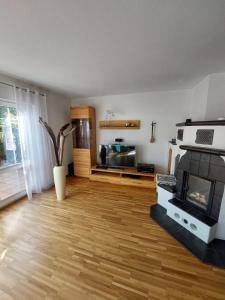 a living room with a fireplace and a wooden floor at Haus auf der Schwäbischen Alb in Grabenstetten