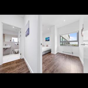 um quarto branco com um lavatório e uma casa de banho em Charming 1 Bedroom Flat in Essex TH620 em Basildon