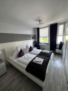 a bedroom with a large bed with purple pillows at Hotel Deutscher Hof in Schleswig