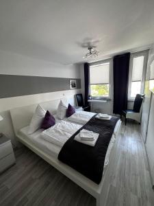 ein Schlafzimmer mit einem großen Bett mit lila Kissen in der Unterkunft Hotel Deutscher Hof in Schleswig
