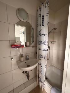 a bathroom with a sink and a shower curtain at Hotel Deutscher Hof in Schleswig