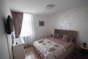 una camera con letto rosa e finestra di Panorama Luxury Apartment a Oradea