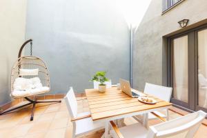 ジローナにあるBravissimo Plaça Catalunya, 2-bedroom apartment with terraceのダイニングルーム(ノートパソコンと椅子付きのテーブル付)