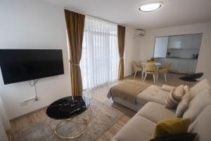uma sala de estar com um sofá, uma televisão e uma mesa em Panorama Luxury Apartment em Oradea