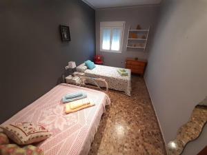 Habitación pequeña con 2 camas y ventana en Casa Rural La Pariente en El Real de la Jara