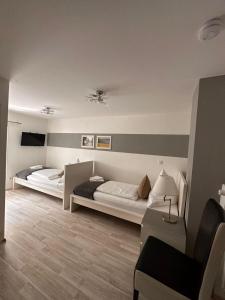 Un dormitorio con 2 camas y una silla. en Hotel Deutscher Hof, en Schleswig