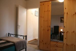 a bedroom with a bed and a large wooden closet at Your Work & Stay Home in Mechernich in Mechernich