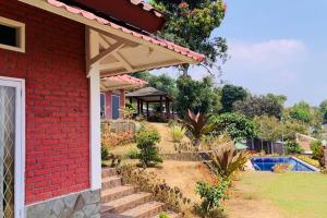 dom z czerwonej cegły z gankiem i ogrodem w obiekcie Villa Kay Valley w mieście Kopo 2