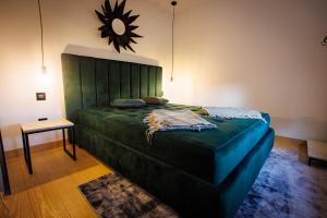 a bedroom with a green bed with a mirror on the wall at Kuća mirne duše in Topola +16 photos