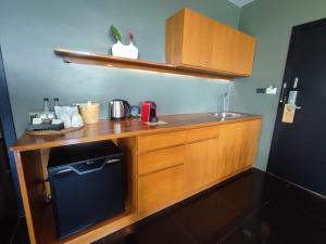 a kitchen with a counter with a sink and a microwave at The Paz Khao Yai in Nong Sarai