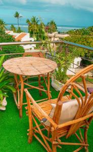 a wooden table and chairs and a table and a table at ZaNaKri Homes ;A Great Panorama of Indian Ocean in Mombasa