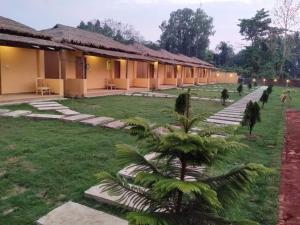 a courtyard of a house with a palm tree in the yard at Angel Resort & Restaurant in Cox's Bazar