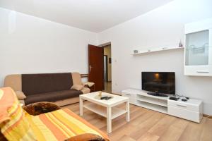 - un salon avec un canapé et une télévision dans l'établissement Apartment Brajdine 405, à Medulin