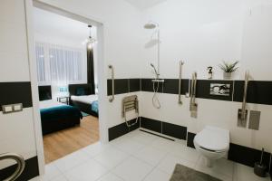 łazienka z toaletą i łóżko w pokoju w obiekcie Erzsébet Vendégház Mórahalom w mieście Mórahalom +37 zdjęć