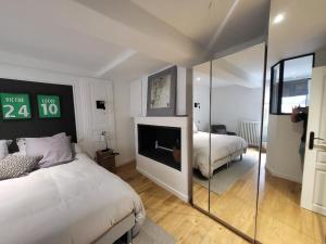 - une chambre d'hôtel avec 2 lits et une cheminée dans l'établissement Superbe 100 M2, 4 chambres, à Sainte-Foy-lès-Lyon