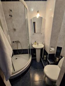 ein Bad mit einer Dusche, einem WC und einem Waschbecken in der Unterkunft Барселона in Odessa
