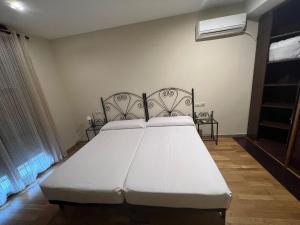 - une chambre avec un grand lit blanc dans l'établissement Hostal el Pasaje, à Puente-Genil