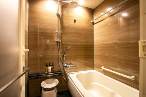 a bathroom with a tub and a toilet and a sink at Minn Sanjo in Kyoto