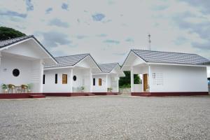 a row of white houses with a gravel driveway at Chanmuang Resort ชานเมืองรีสอร์ท in Phetchaburi