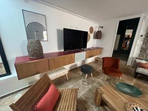  Il comprend un salon doté d'une télévision murale à écran plat. dans l'établissement Maison T4 centre ville et plage, à Balaruc-les-Bains