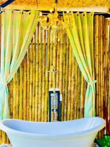 a bath tub in front of a bamboo wall at Bridge Hill Cafe Glamping in Khao Sok