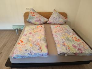 Una cama con dos almohadas encima. en Design-Studio am Salerhof, en Bad Wurzach