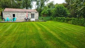 a yard with a small house and a green lawn at Maison à la campagne,à Saint-amand, Pas-de-Calais in Saint-Amand