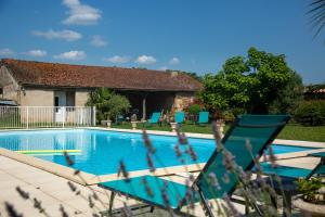 a swimming pool with a chair and a house at Sarl Château Arago in Fauguerolles