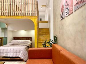 a bedroom with a bunk bed and a couch at JORA LOFT - Japandi inspired apt 1- D in Dagupan