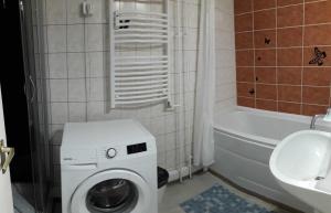 een badkamer met een wasmachine en een wastafel bij Sweet Dreams Apartman in Nyíregyháza