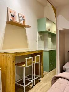 uma cozinha com duas cadeiras e um balcão num quarto em JORA LOFT - Japandi inspired apt 1- D em Dagupan