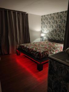 1 dormitorio con 1 cama con luz roja en Chez Stéphanie et Sylvain, en Le Mesnil-Villeman