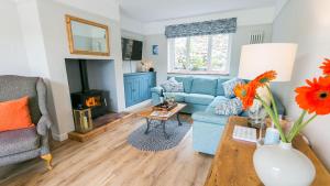 a living room with a blue couch and a fireplace at Noddfa in Menai Bridge