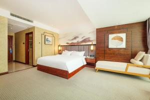 ein Schlafzimmer mit einem großen weißen Bett und einem Sofa in der Unterkunft Xiamen Xiangzun Hotel - Huijing Plaza Branch in Xiamen
