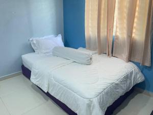 Cama con sábanas blancas y almohadas junto a una ventana en 3Bedroom Full AirCond House with Pool@PortDickson en Port Dickson