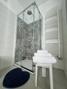 baño con ducha y mesa blanca con toallas en La Ringhiera, en Novara
