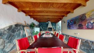 a dining room with a long table and red chairs at Bellavista in San Bartolomé de Tirajana