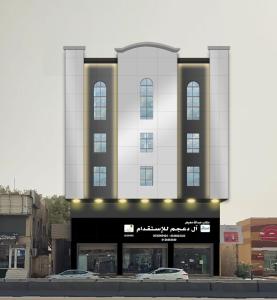 a large white building with windows on a street at شقق ابراج الثريا للشقق المخدومة in Al Fayşalīyah