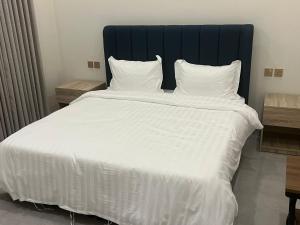a large white bed with white sheets and pillows at شقق ابراج الثريا للشقق المخدومة in Al Fayşalīyah