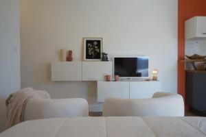een woonkamer met een tv en 2 stoelen bij Studio terrasse Parking CLIM sans vis à vis in La Grande-Motte