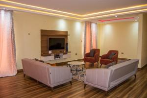 - un salon avec deux canapés et une télévision dans l'établissement Ista Villa, à Lusaka