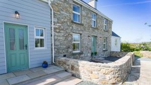 LlanddyfnanにあるPen y Fan Bellafの緑の扉と石壁の石造りの家