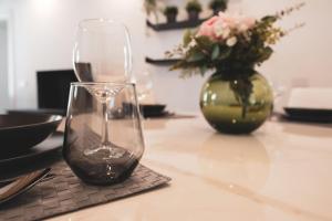 un tavolo con due bicchieri da vino e un vaso di fiori di Modern Apartment Lungolago di Como a Como