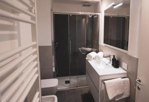 e bagno con doccia, servizi igienici e lavandino. di Modern Apartment Lungolago di Como a Como