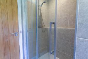 a bathroom with a shower with a glass door at Pant yr Afallen in Llanallgo
